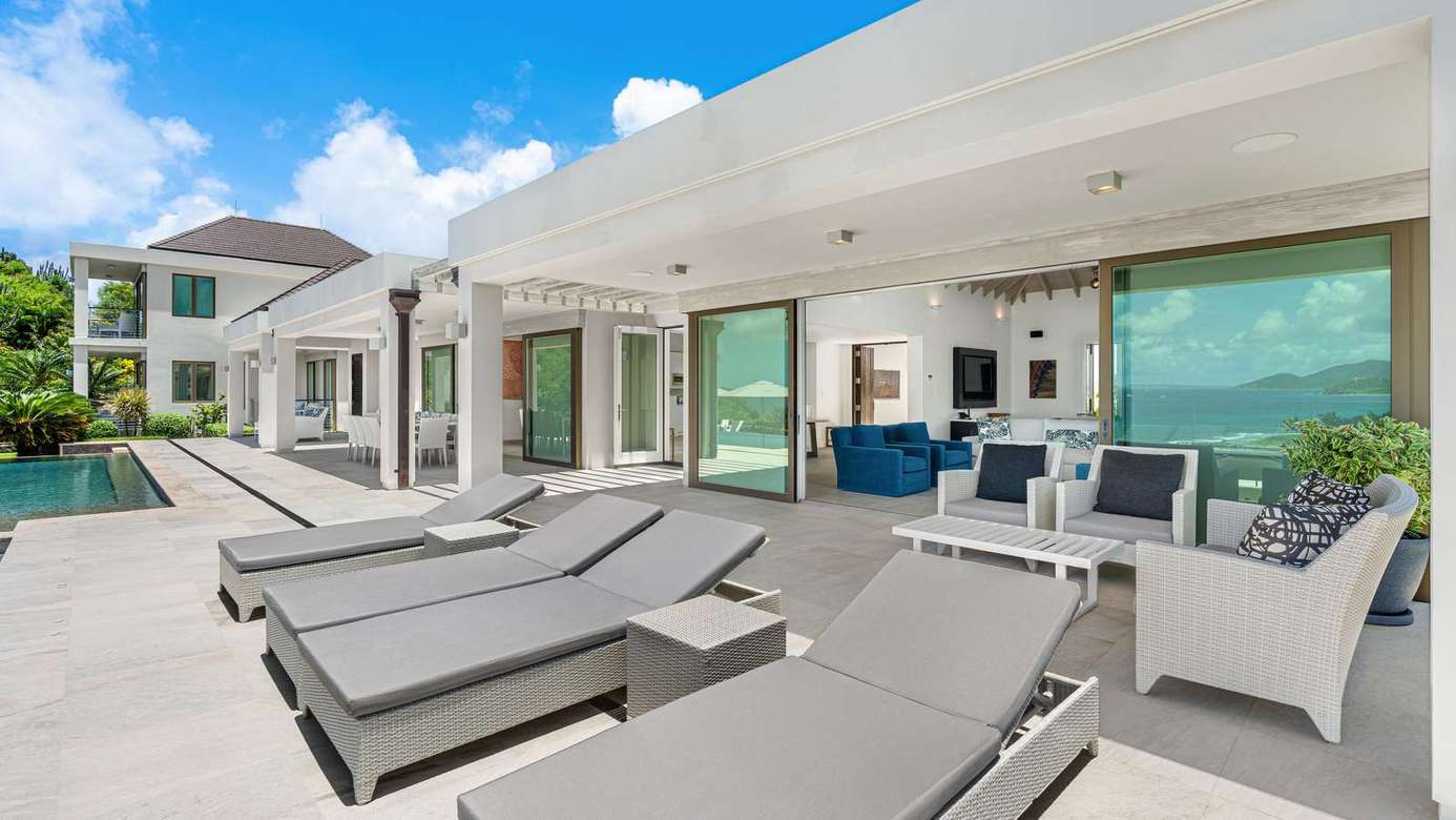Spacious outdoor patio with loungers and ocean views
