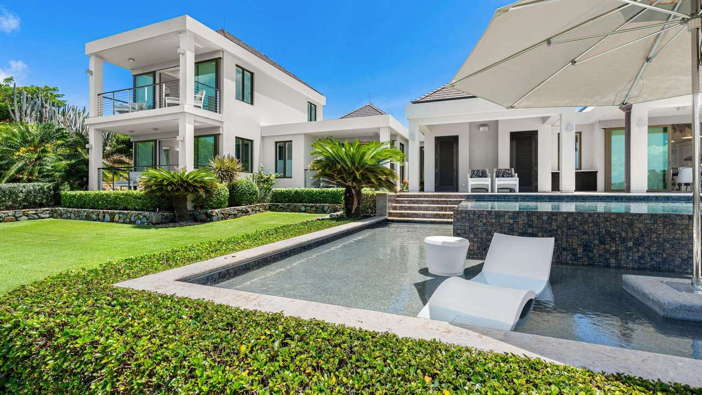Luxurious backyard oasis with poolside loungers and spacious patio