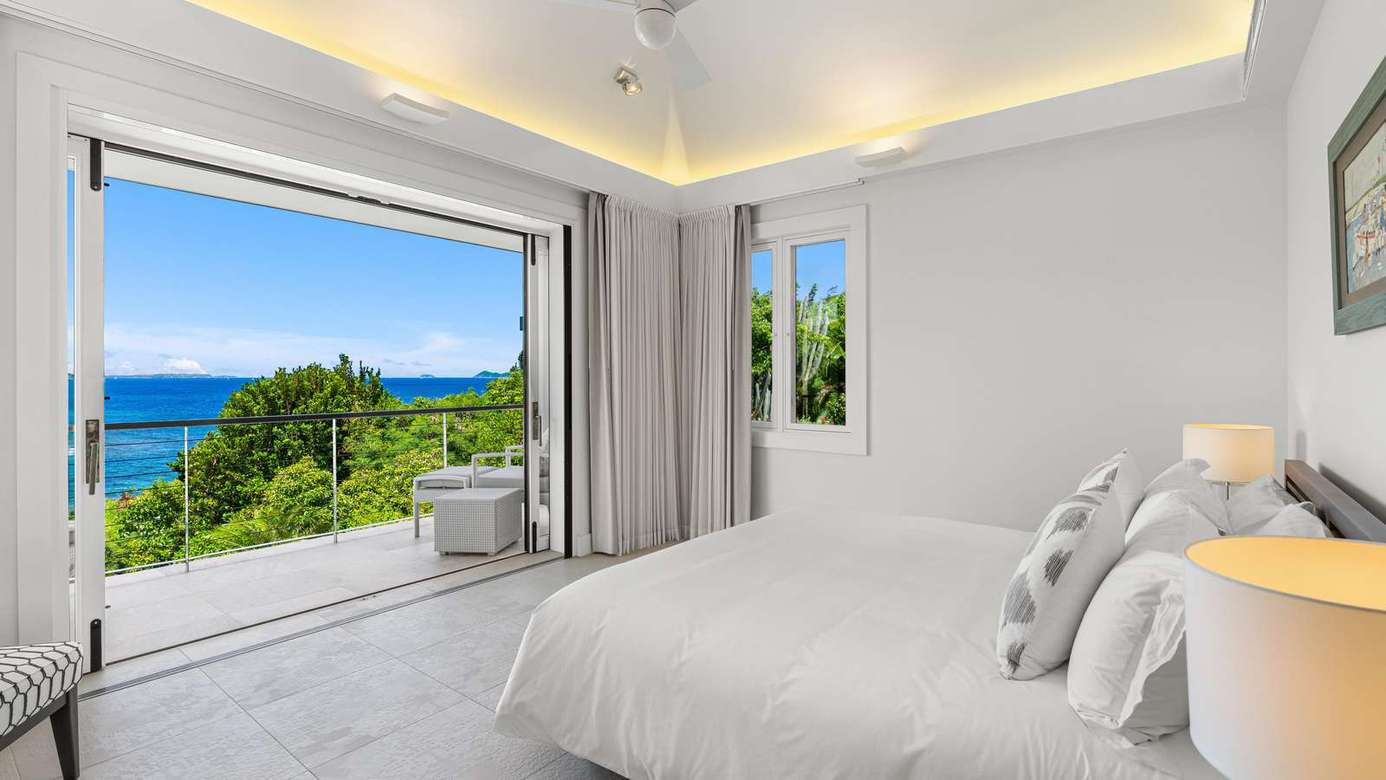 Bright bedroom with ocean views and seamless indoor-outdoor flow