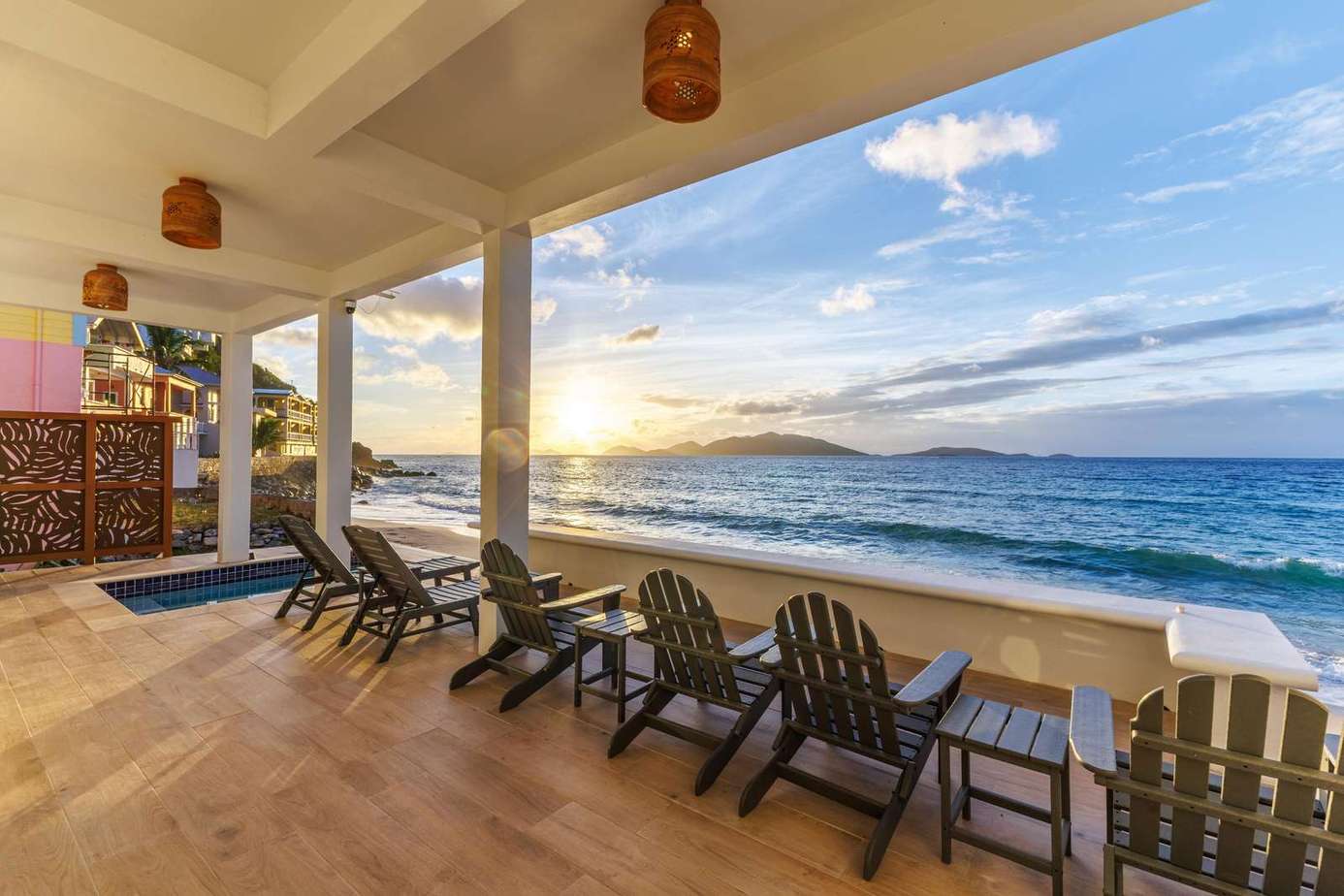 Oceanfront patio with stunning sunset and relaxing lounge chairs