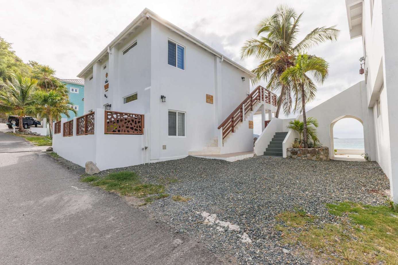 Bright, airy exterior with tropical palm accents and private entry