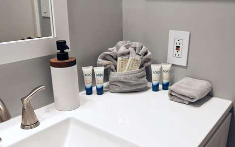 Modern bathroom sink with plush towels and luxury toiletries