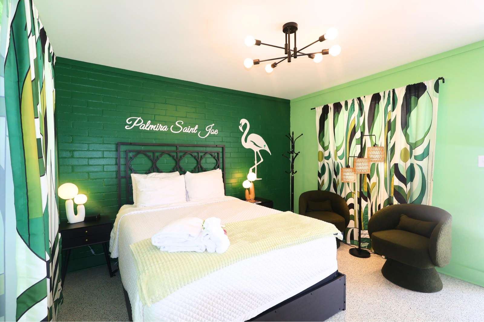 Bright, tropical-themed bedroom with cozy seating nook - property