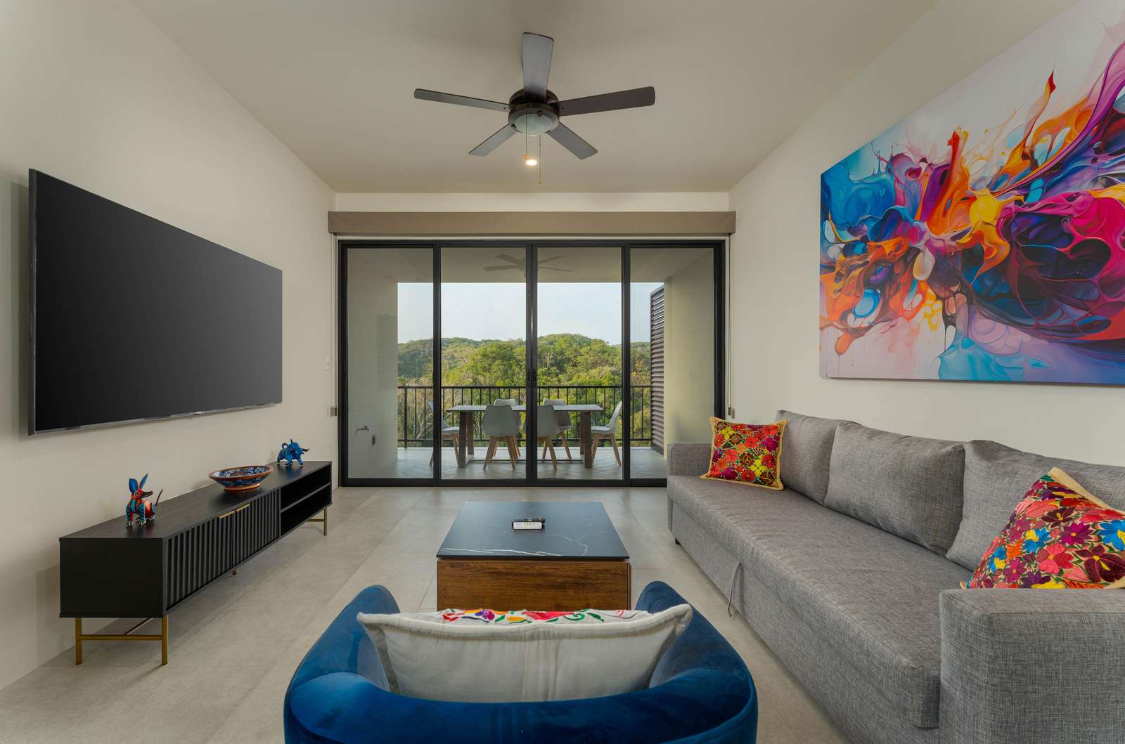 Bright living room with scenic balcony views and vibrant art - property