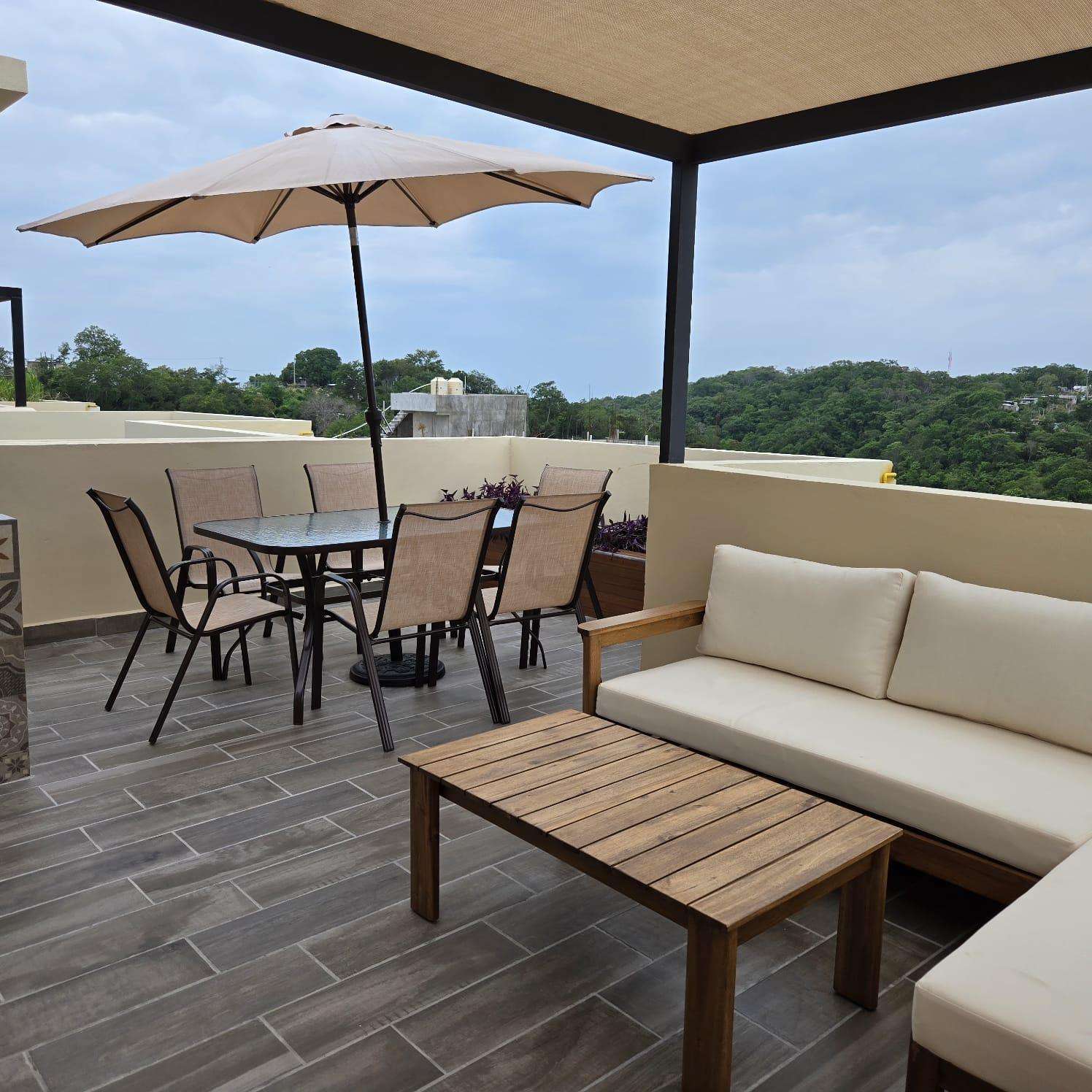 Spacious rooftop patio with cozy seating and scenic views - property