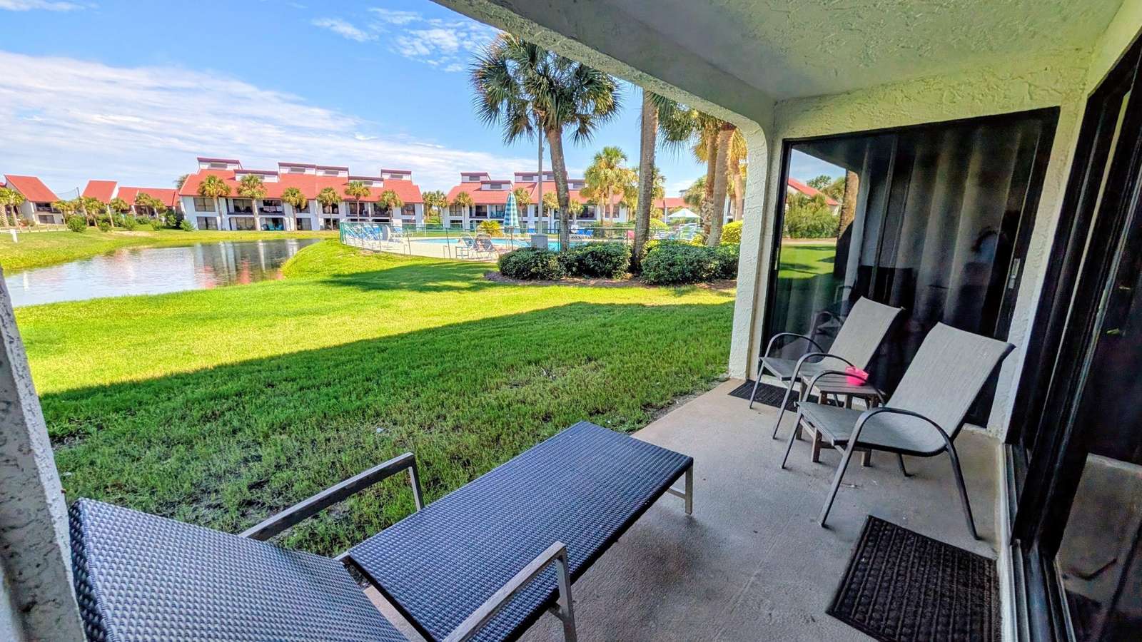 Ground floor patio with lake and pool views. - property