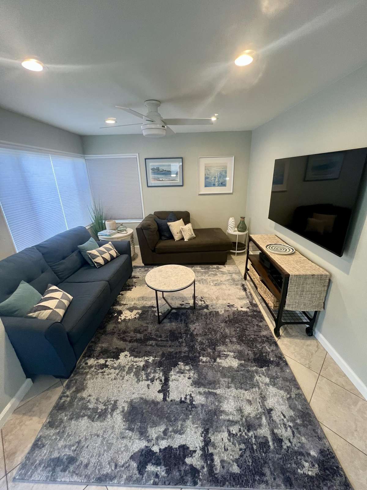 Cozy living room with plush seating and large TV for relaxing nights. - property