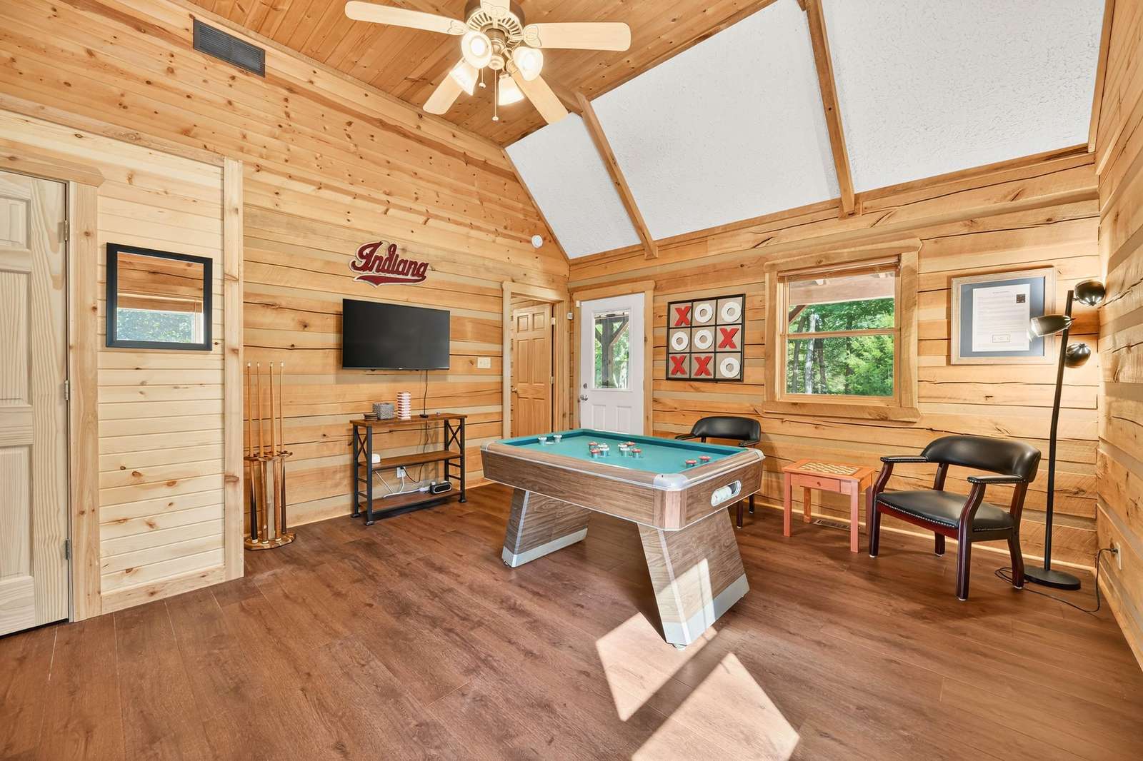Cozy game room with vaulted ceilings and rustic charm