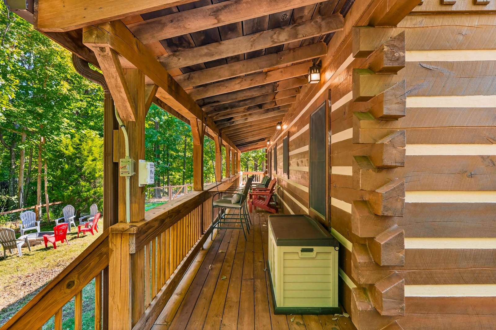 Spacious covered porch with cozy seating and forest views