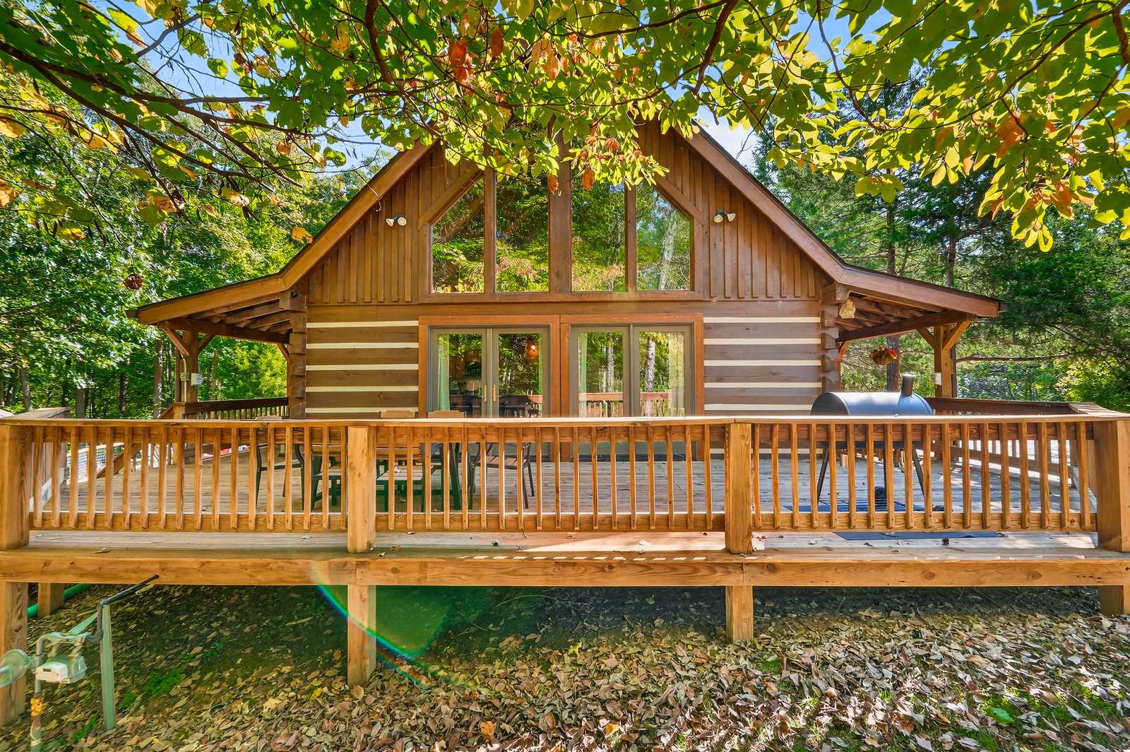 Spacious log cabin with expansive deck surrounded by trees