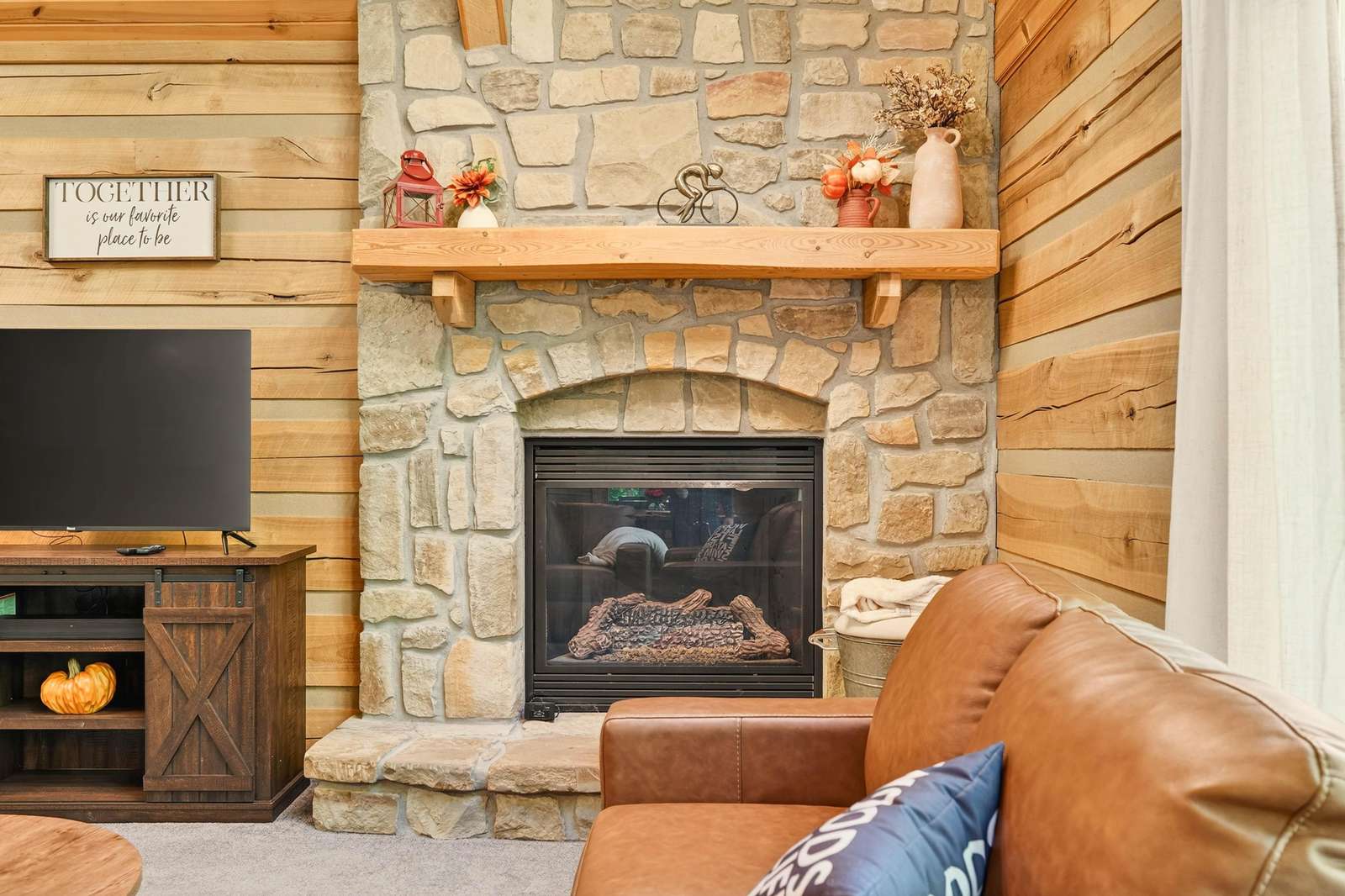 Cozy living room with rustic stone fireplace and warm wood accents