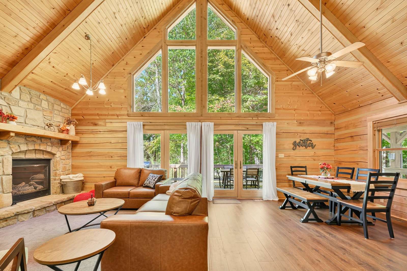 Spacious living and dining area with vaulted ceilings and forest views