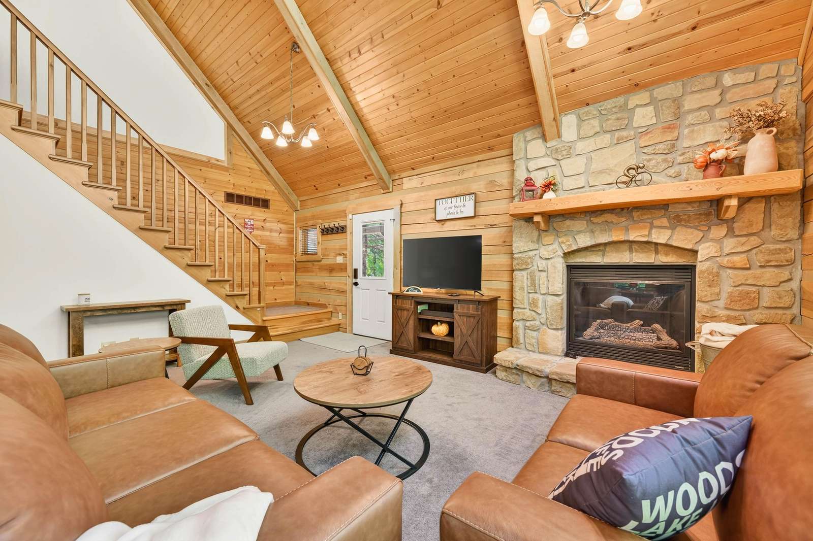 Cozy living room with vaulted ceilings and stone fireplace