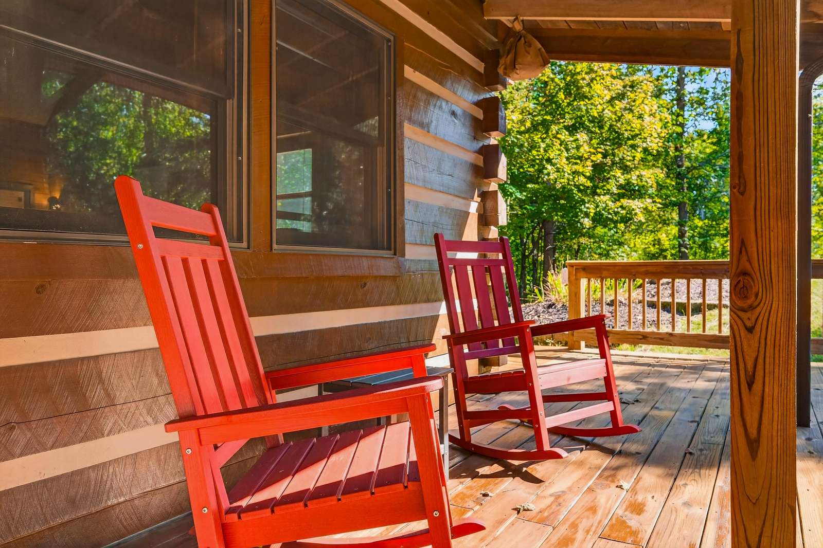 Cozy porch retreat with vibrant rocking chairs and forest views