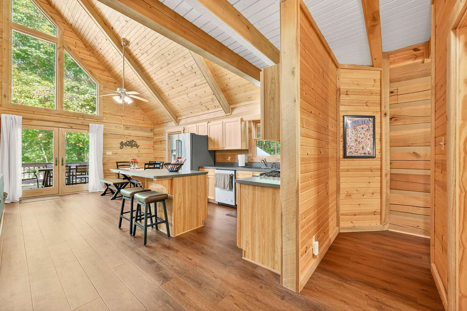 Sunlit open-concept kitchen and living area with vaulted ceilings