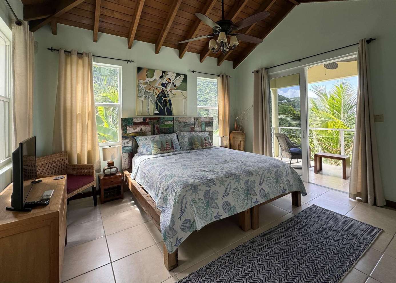 Cozy bedroom with vaulted ceilings and private balcony views