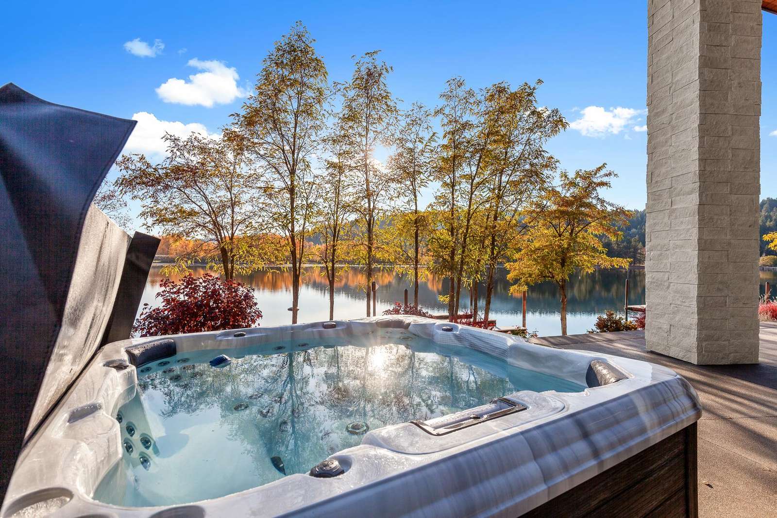 Relax in the bubbling hot tub with serene lake views