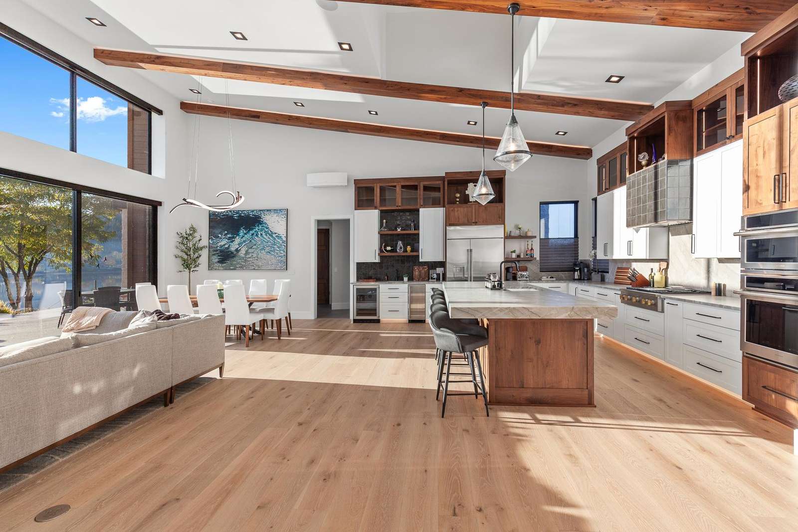 Sunlit open-concept kitchen and living room with scenic views