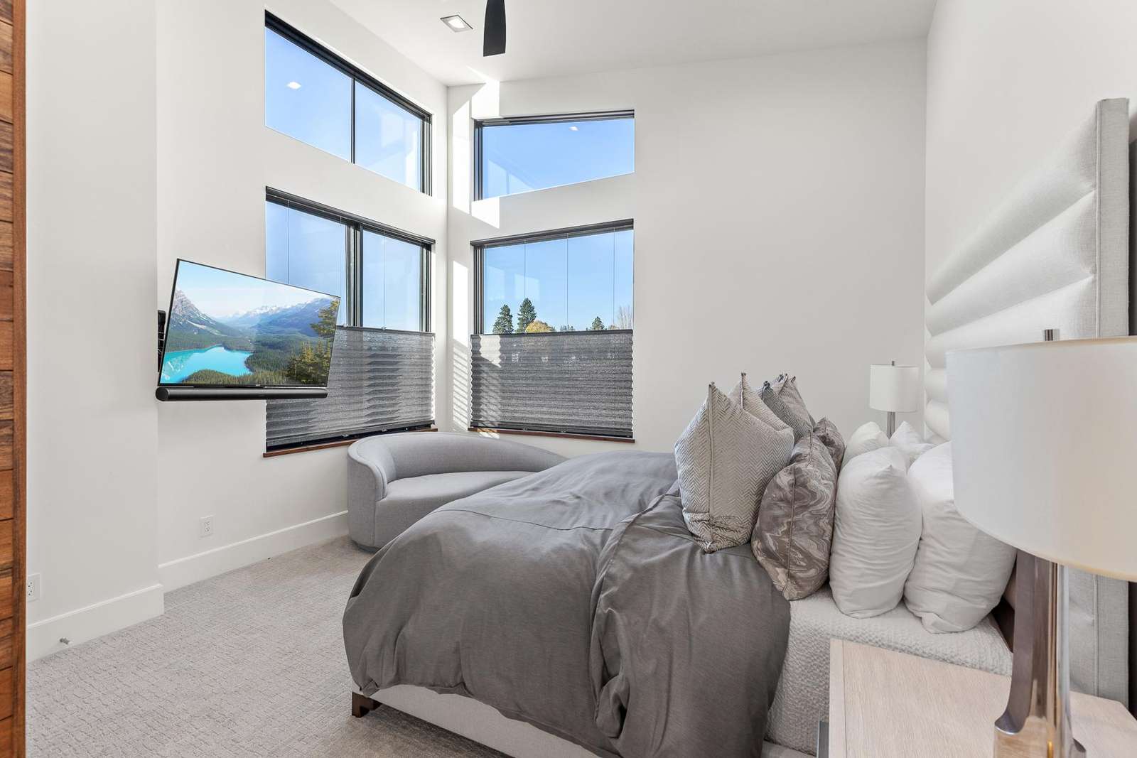 Sunlit bedroom retreat with cozy seating and scenic views