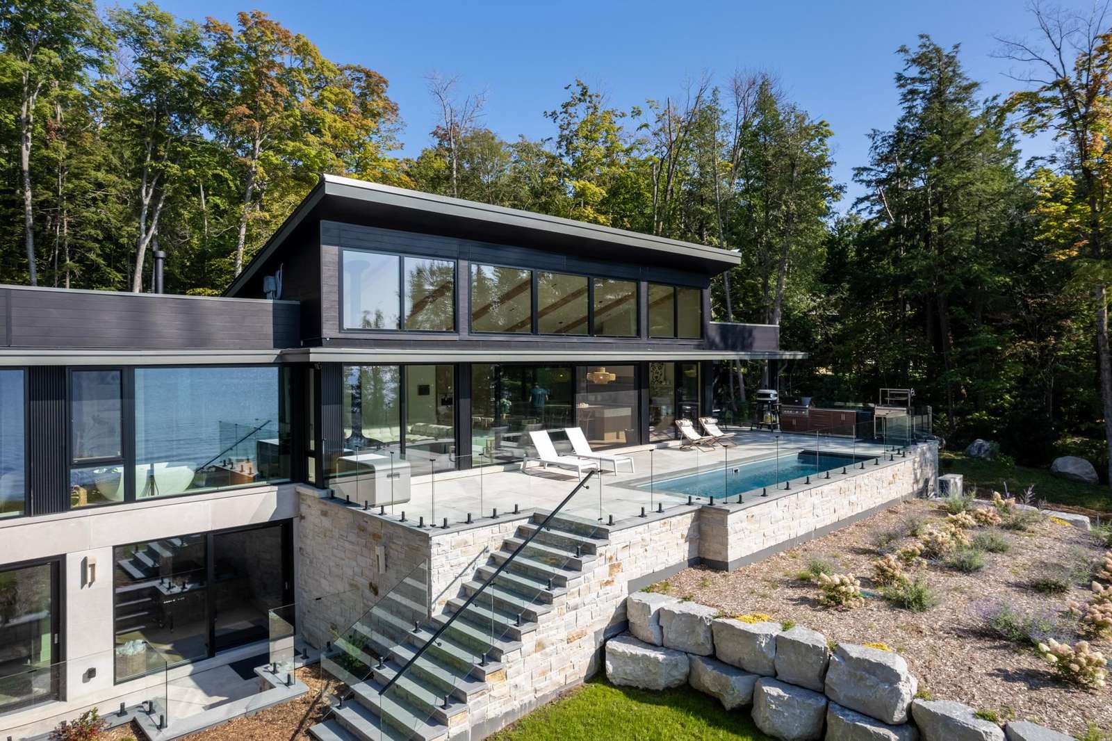 Sleek modern patio with infinity pool and forest views