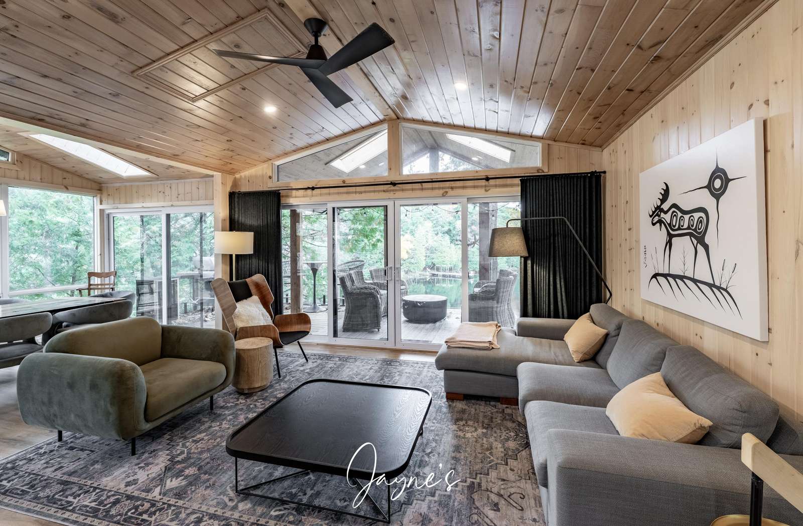 Cozy living room with vaulted ceilings and forest views