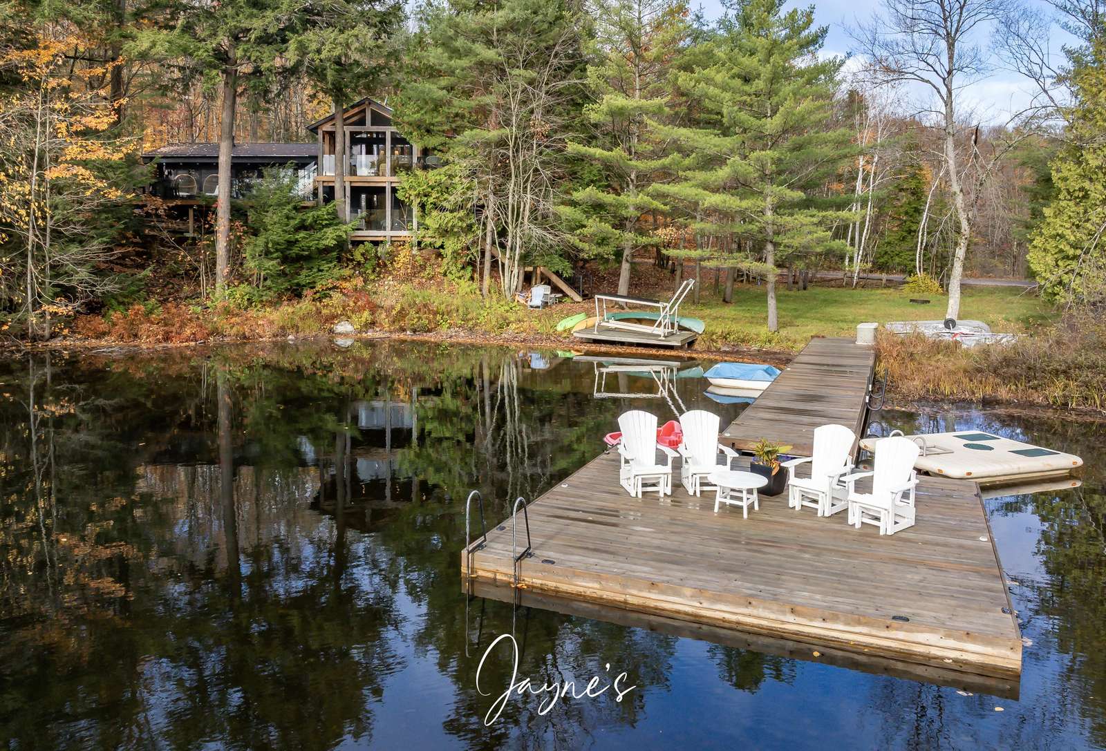 Tranquil lakeside dock with cozy seating for sunset views - property