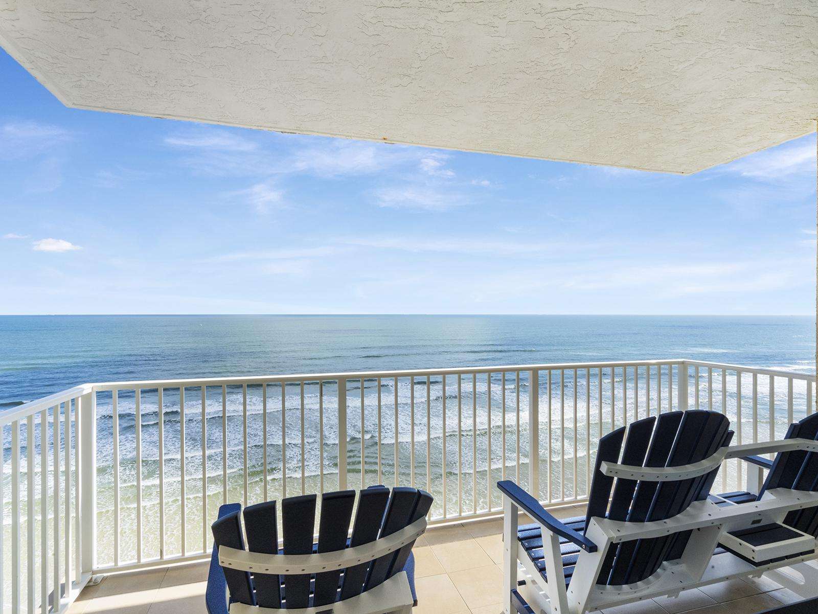 Oceanfront balcony with panoramic sea views and cozy seating - property