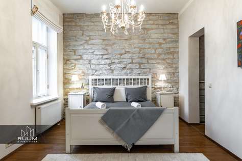 Charming bedroom with exposed brick and elegant chandelier