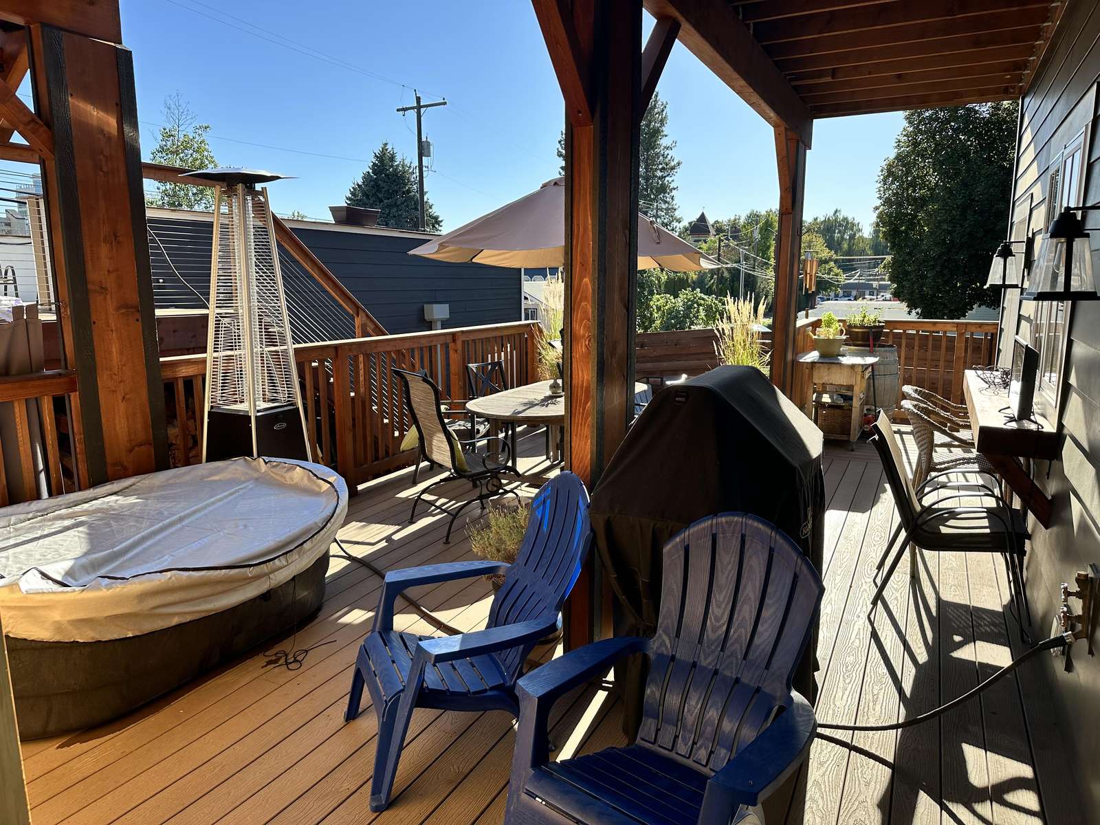 Cozy covered deck with hot tub and outdoor seating