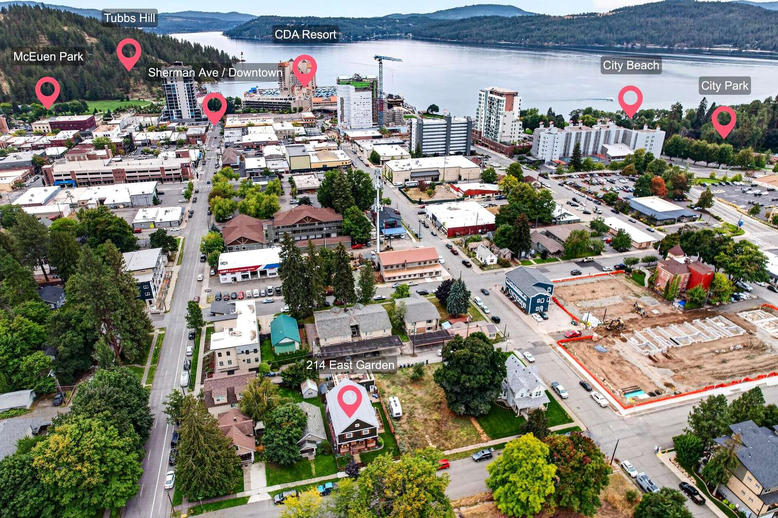Aerial view of downtown neighborhood with tree-lined streets, residential homes, and Lake Coeur d'Alene in the distance.