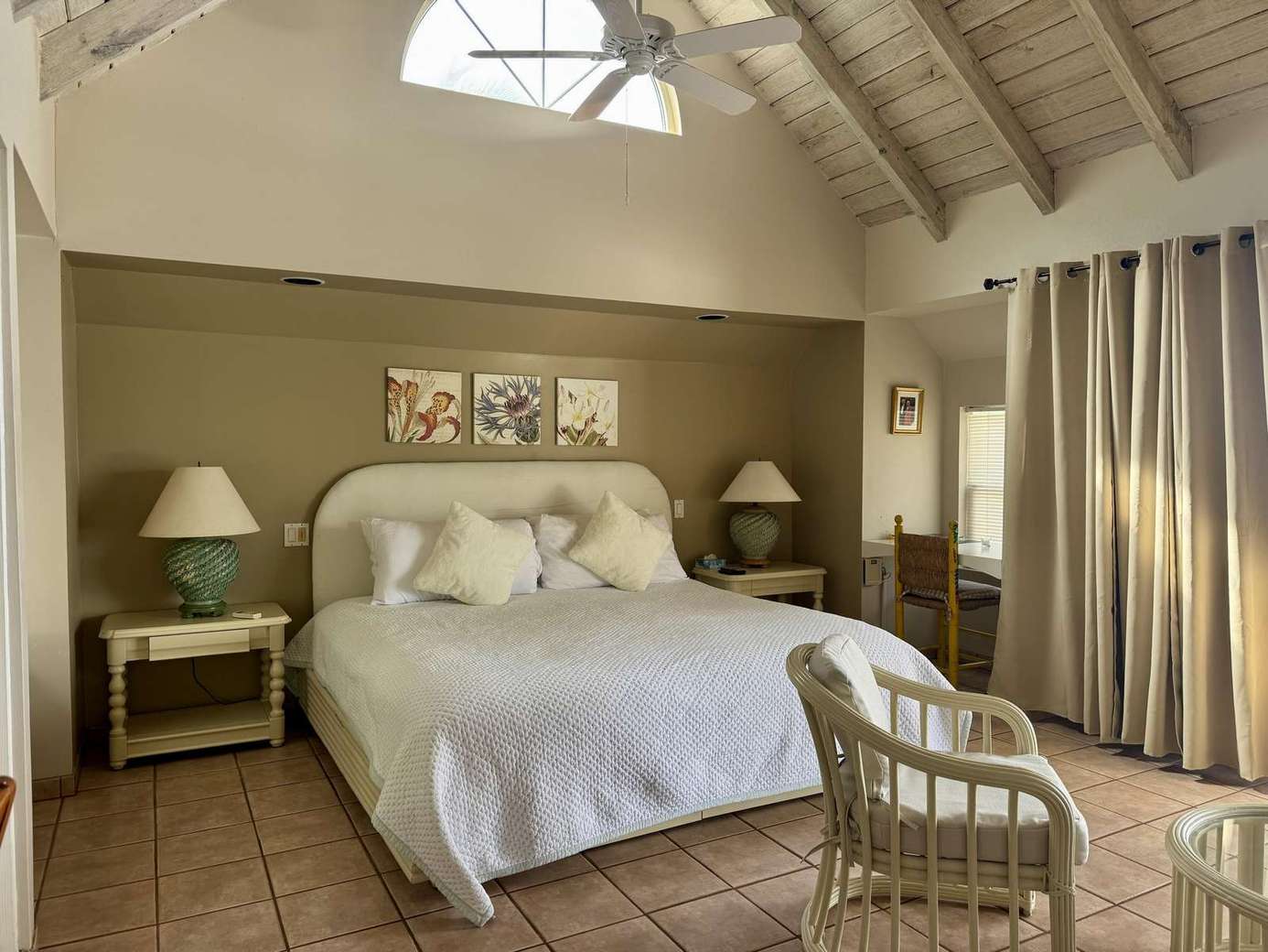 Bright and airy bedroom with vaulted ceilings and cozy seating