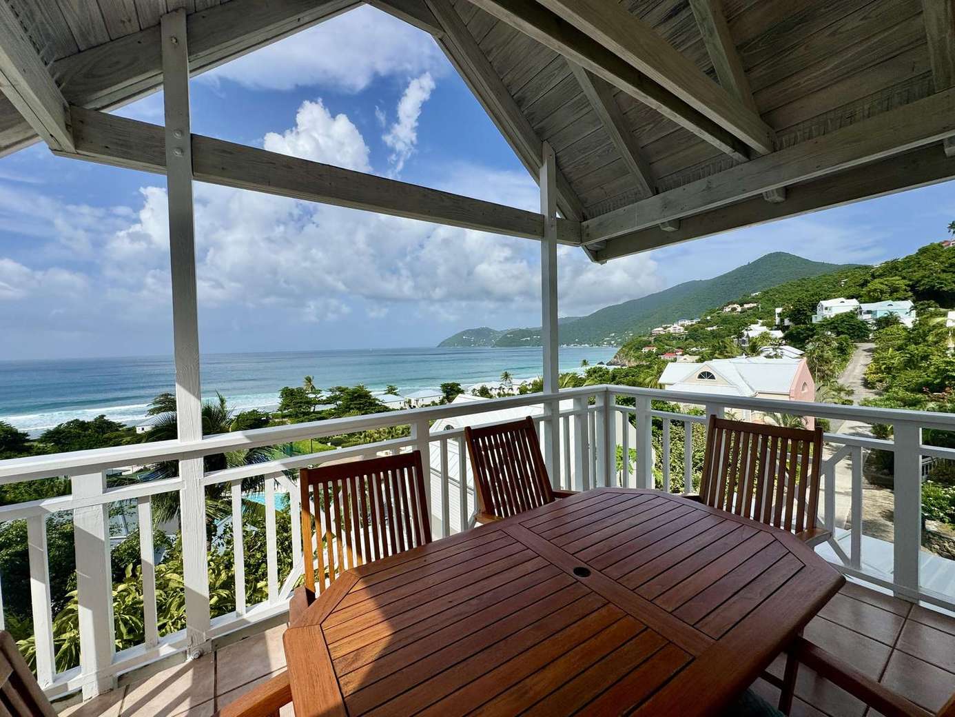 Spacious balcony with panoramic ocean views and cozy seating