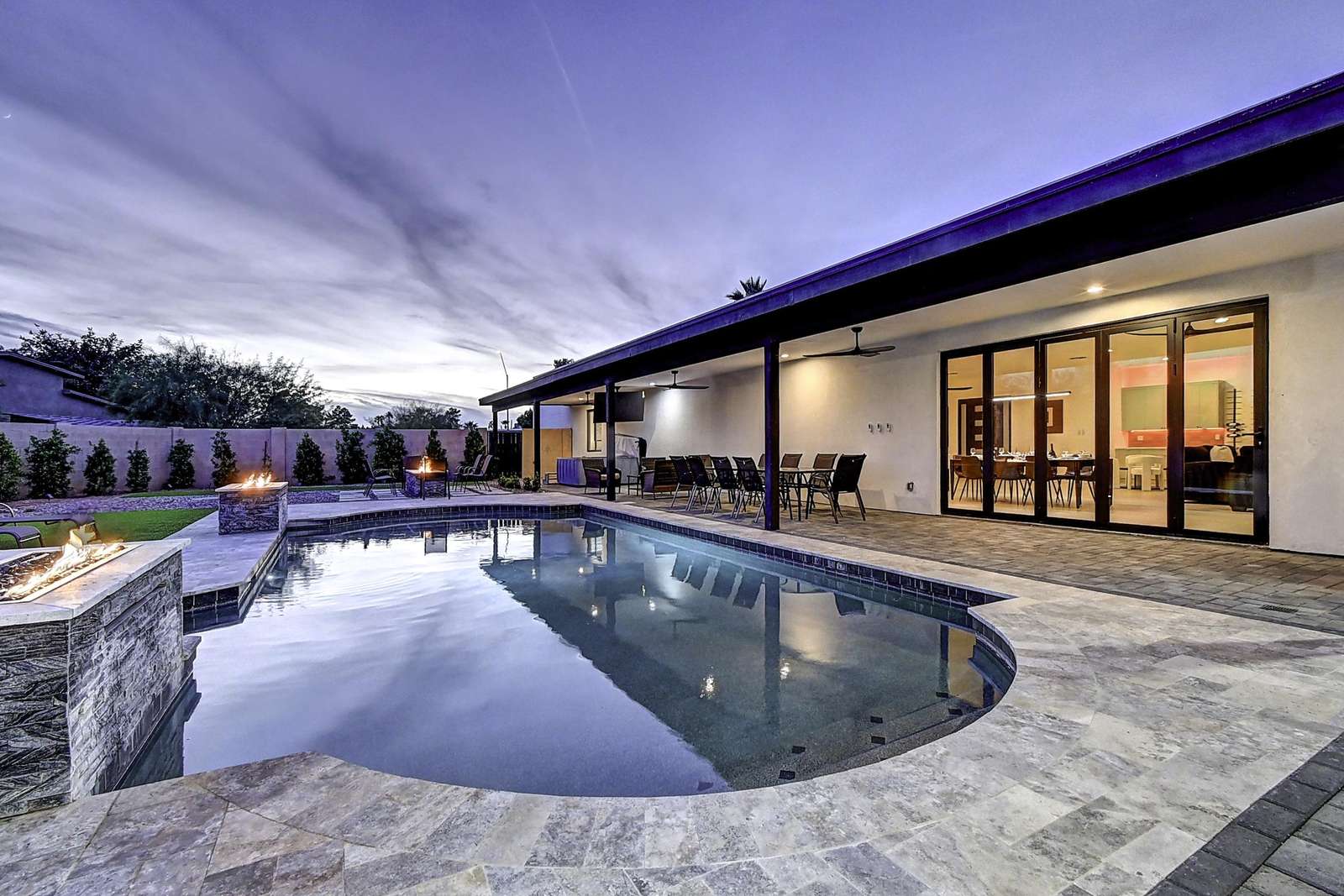 Spacious backyard patio with sparkling pool and sunset views - property