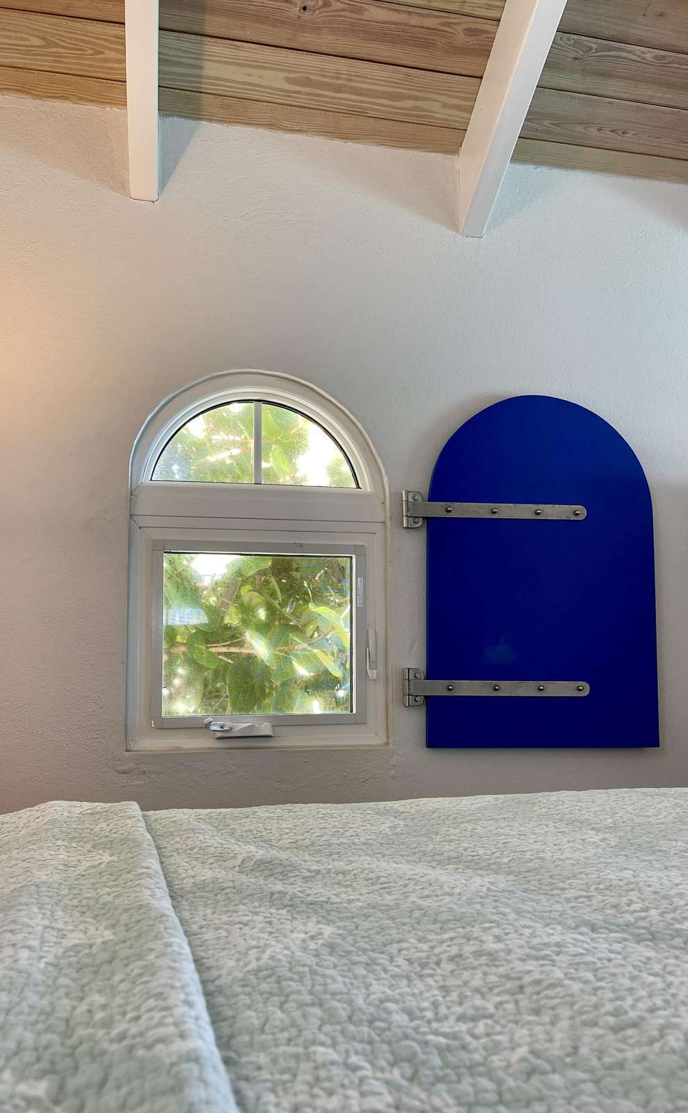 Cozy bedroom nook with charming arched windows and natural light