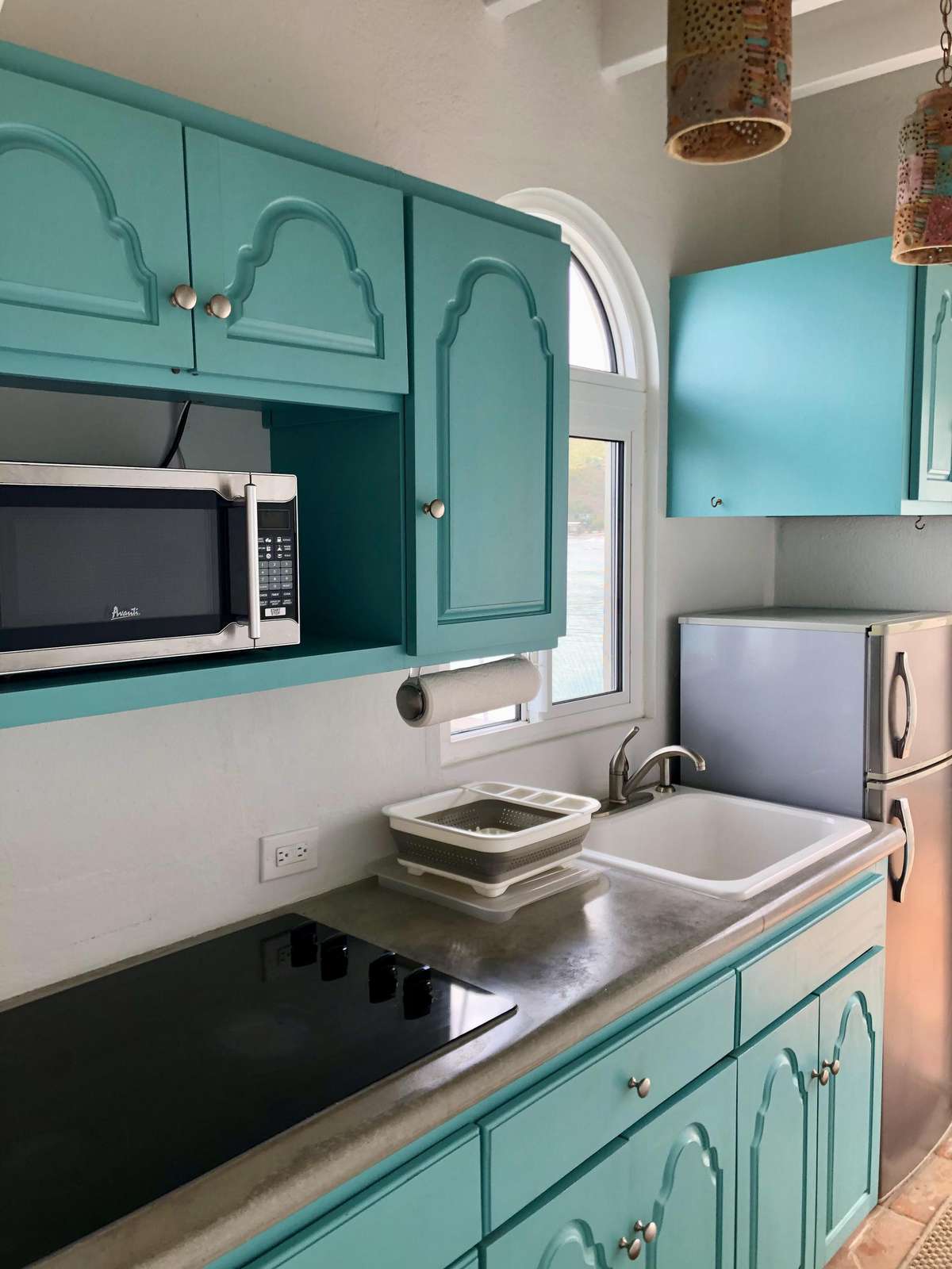 Charming turquoise kitchen with modern appliances and cozy charm