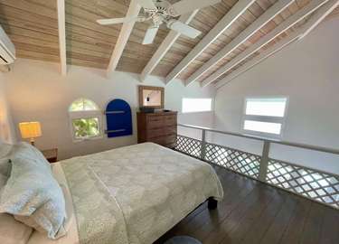 Cozy loft bedroom with vaulted ceilings and natural light