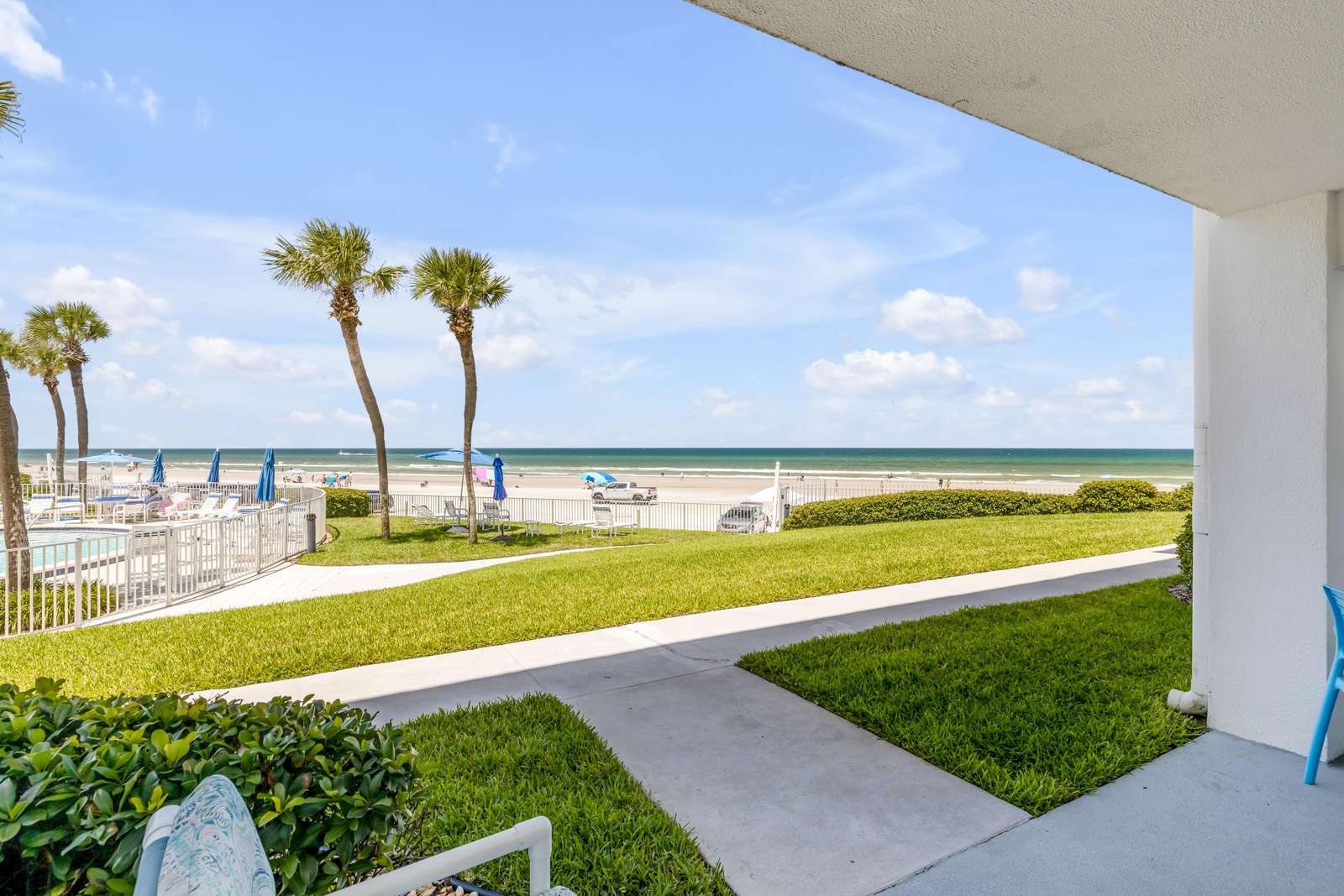 Oceanfront patio with stunning beach and palm tree views - property
