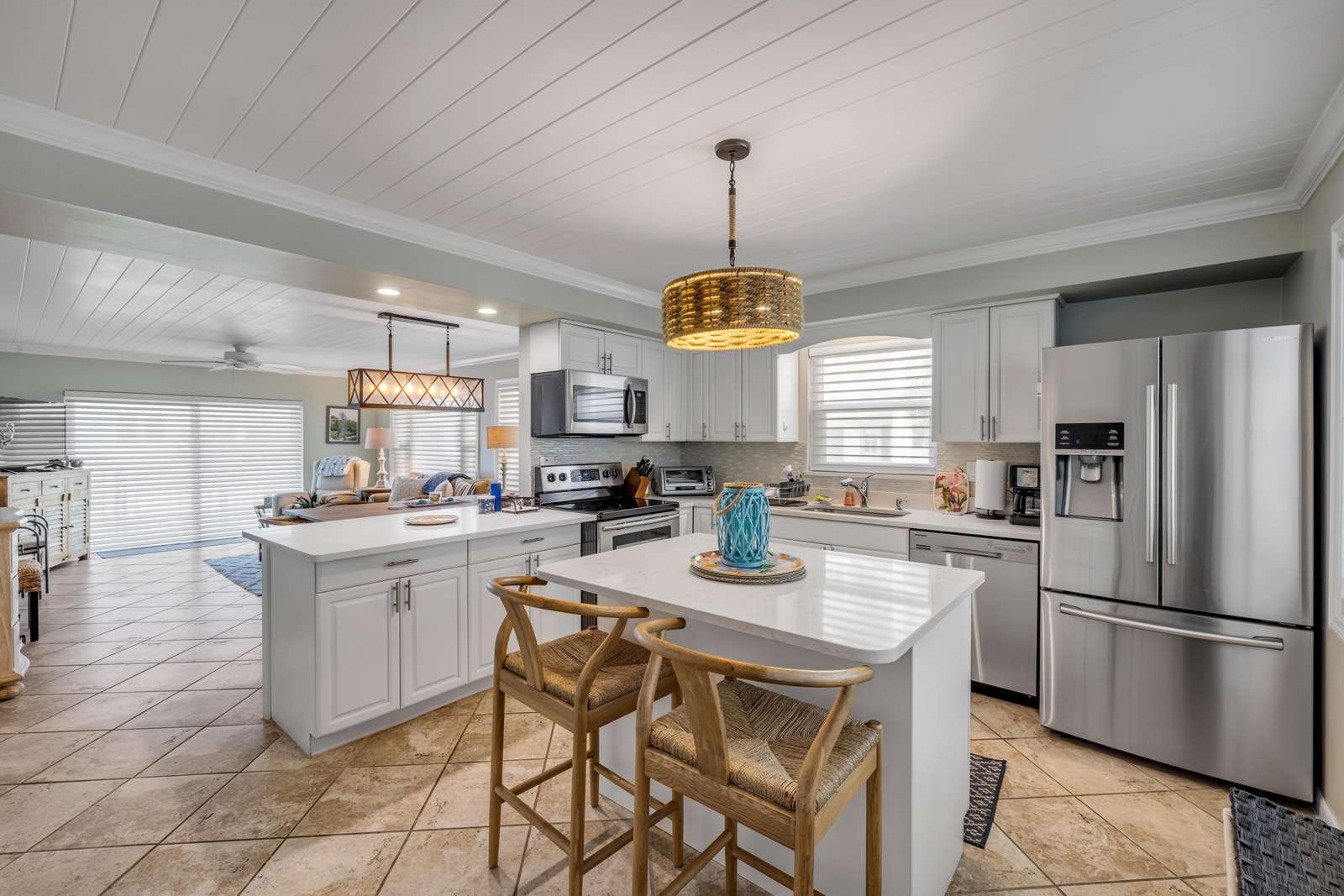 Bright, open kitchen with modern appliances and cozy seating - property