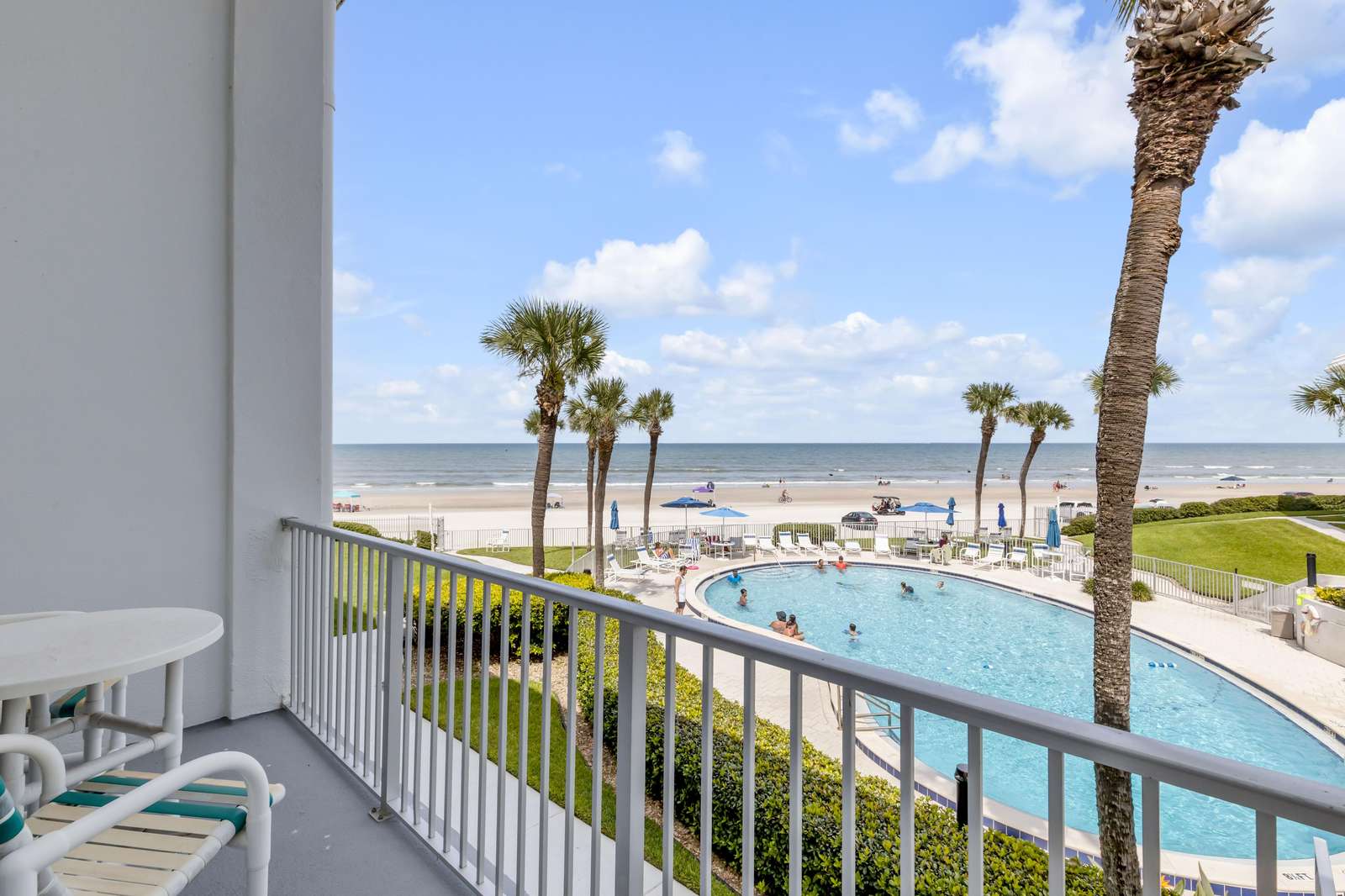 Oceanfront balcony with pool view and palm trees - property
