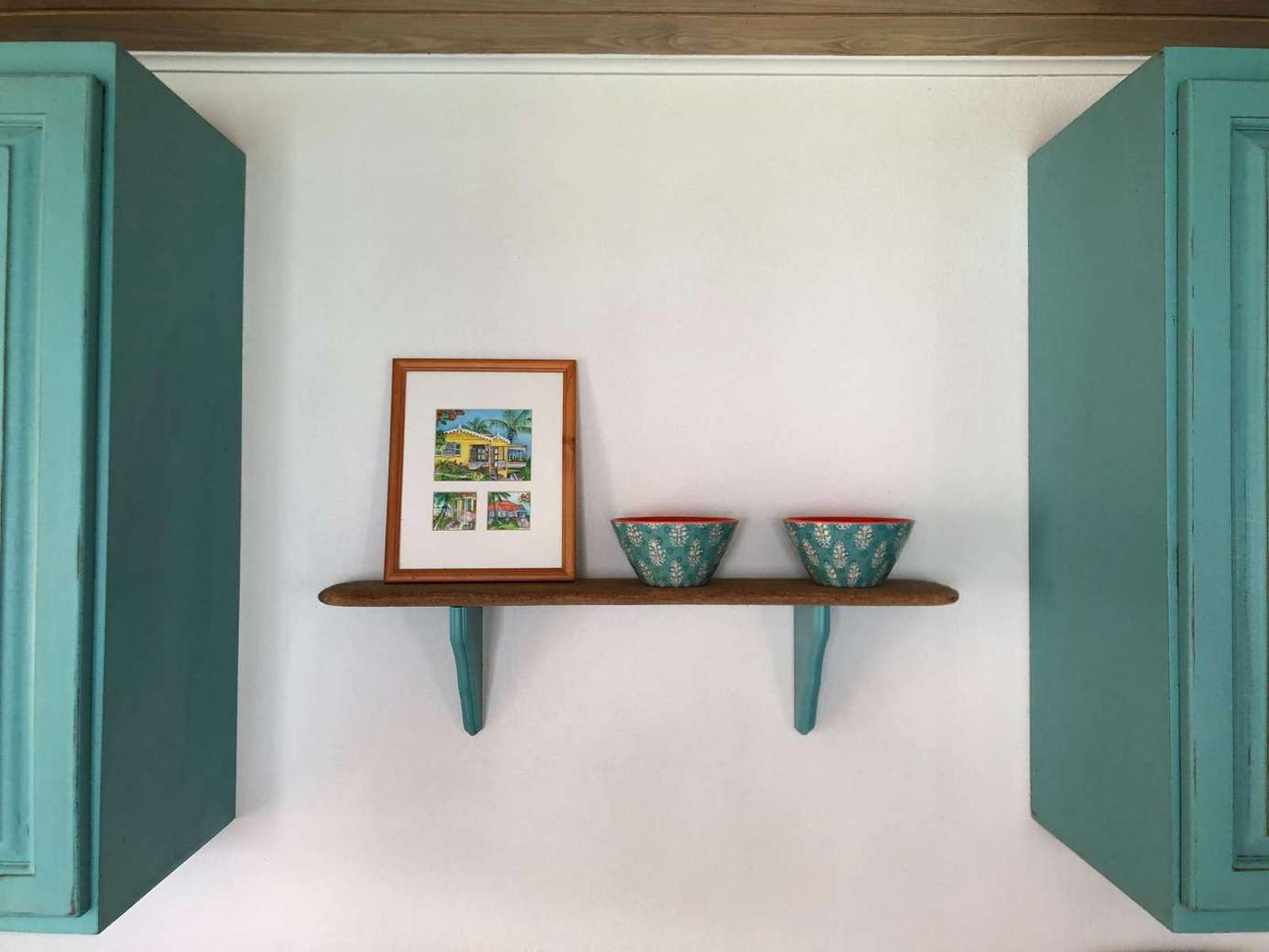 Charming kitchen nook with vibrant teal cabinetry and open shelving