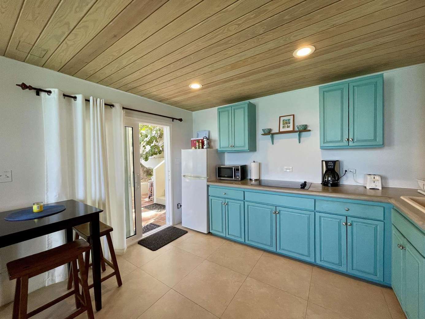 Bright kitchen with turquoise cabinets and cozy dining nook