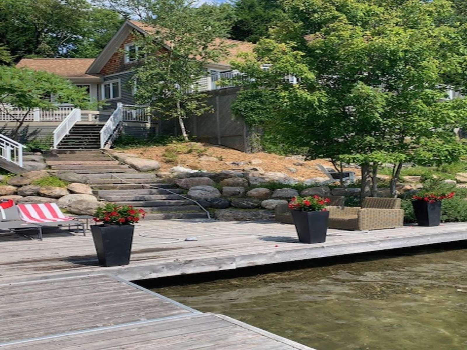 Peaceful lakeside dock with cozy seating and lush greenery