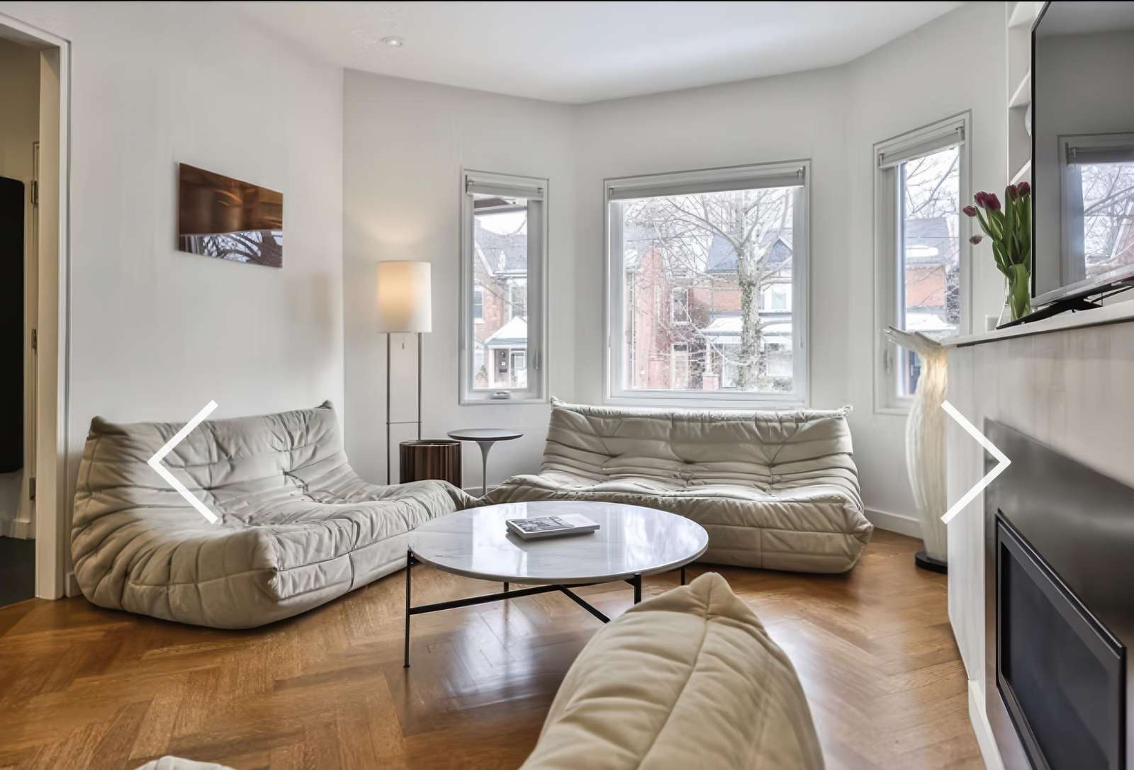 Sunlit living room with cozy seating and city views - property