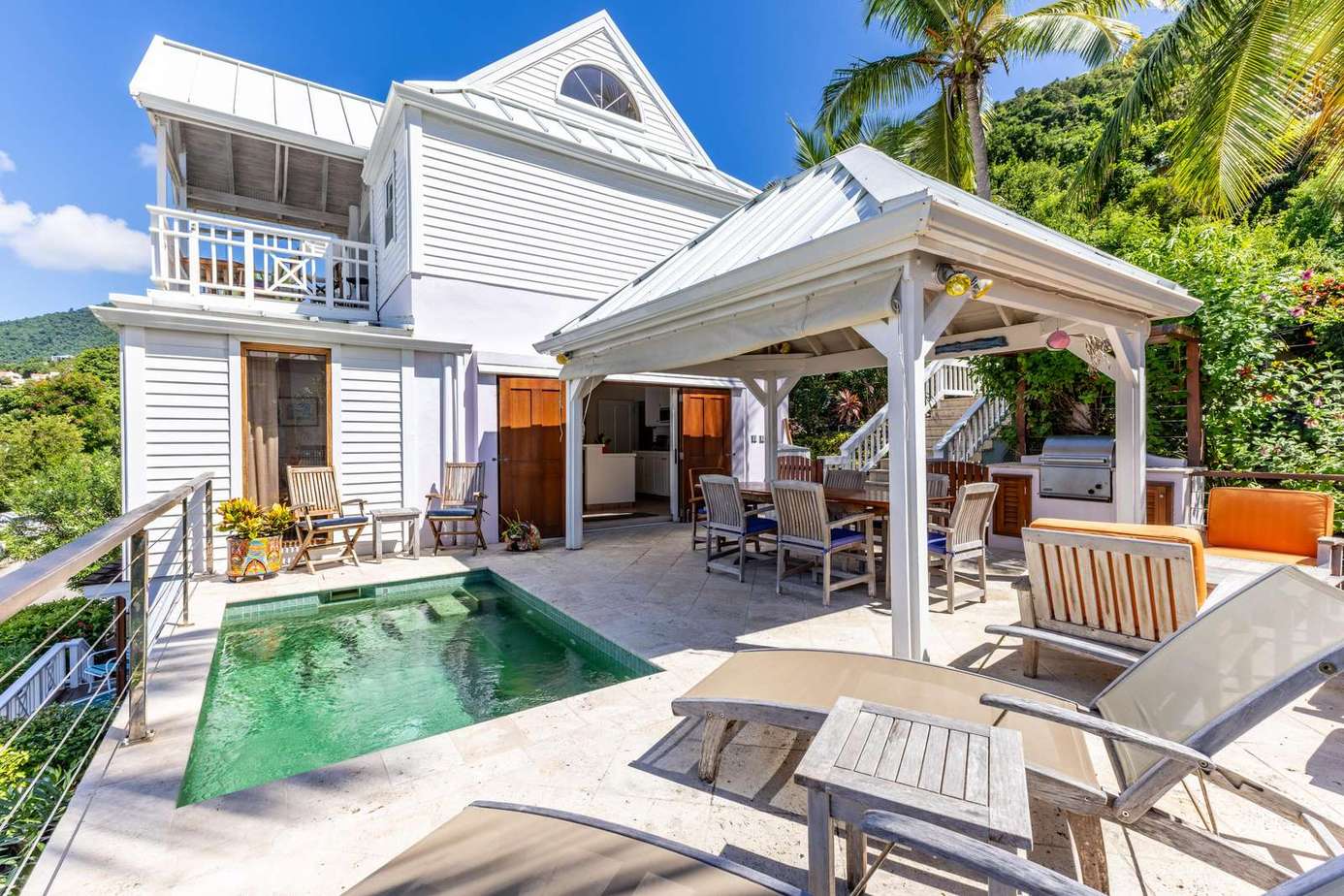 Sunlit patio with pool and cozy outdoor seating