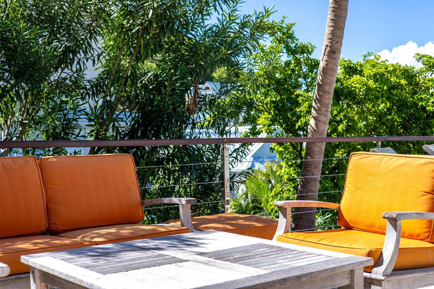 Sunny outdoor lounge with vibrant cushions and lush greenery