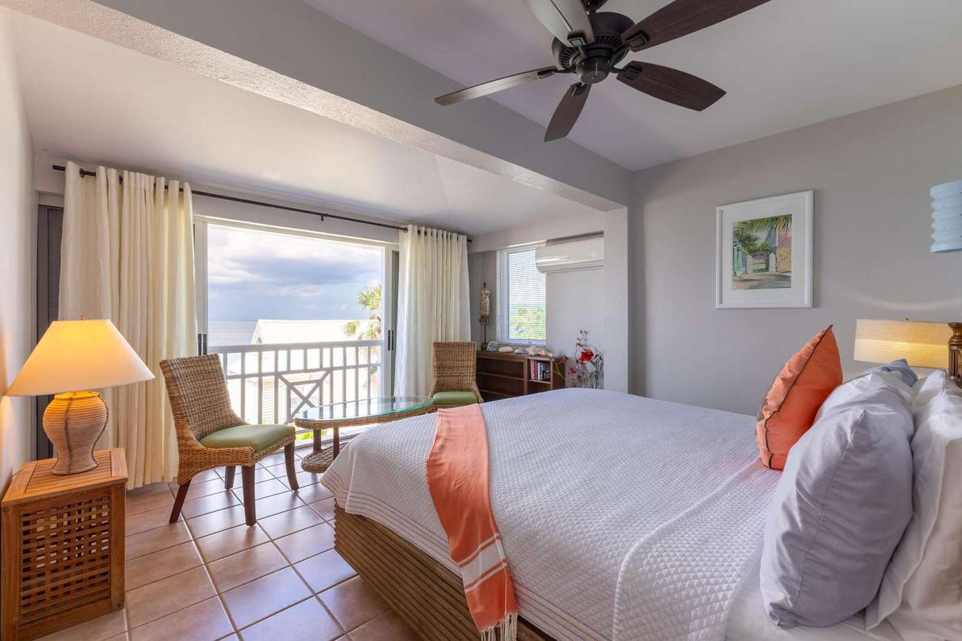 Bright and airy bedroom with ocean views and cozy seating