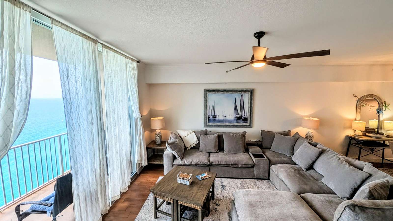 NEW Down sectional sofa anchors the living room with ceramic tile flooring, charming decor, and sheer curtains framing expansive Gulf views. - property