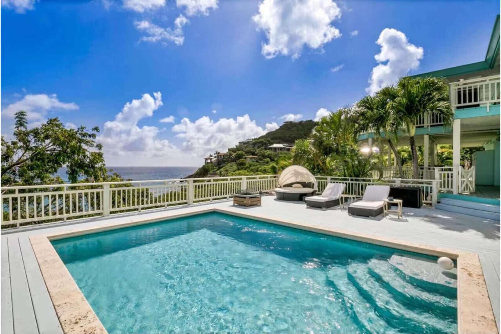 Sun-drenched pool deck with panoramic hillside views - property