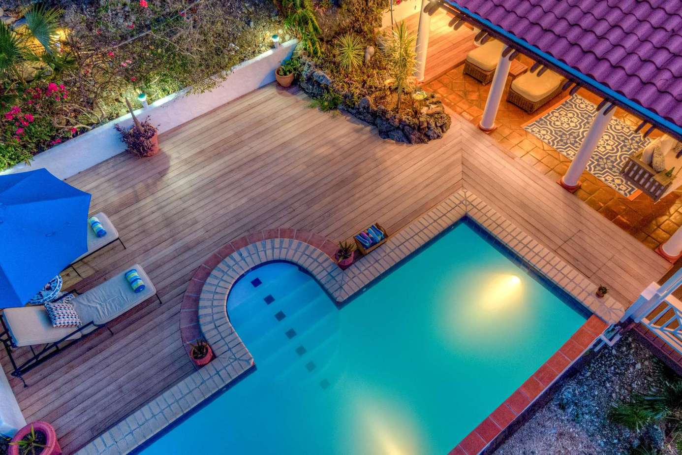Secluded poolside deck with cozy lounge and dining area