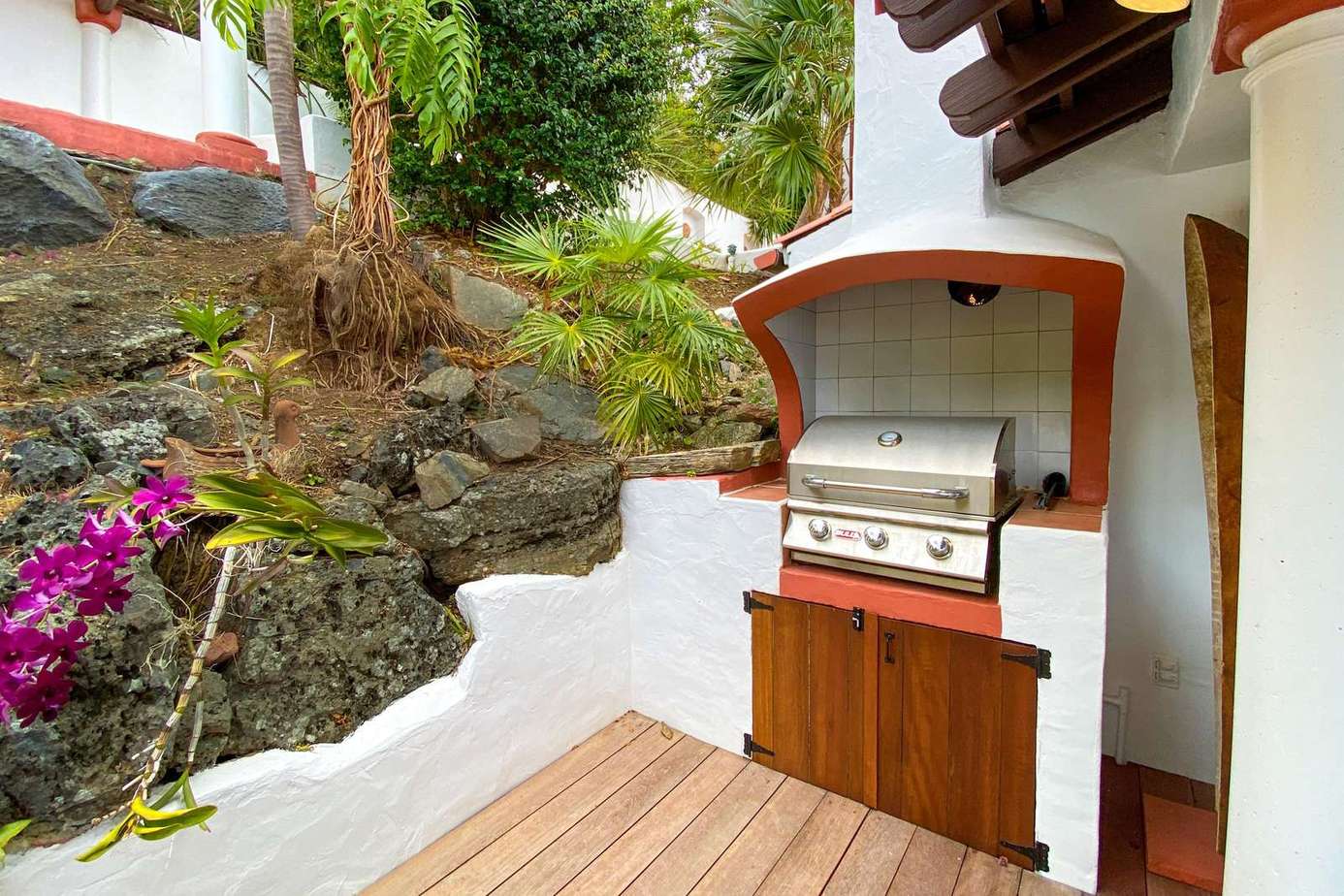 Secluded outdoor grill area surrounded by lush greenery